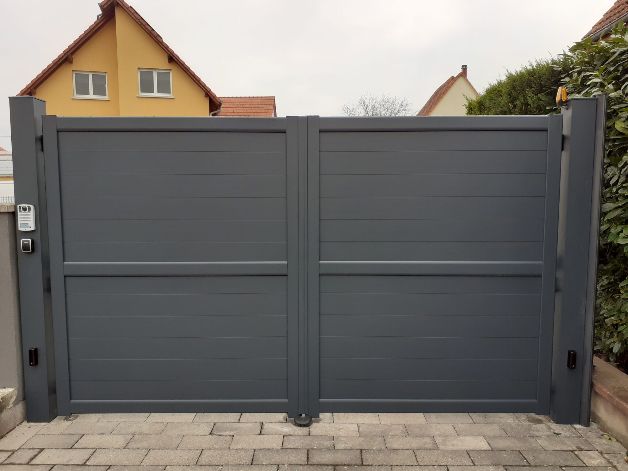 Portail deux battants plein en aluminium gris avec contrôle d'accès par visiophone et lecteur de badge à Oberschaeffolsheim.
