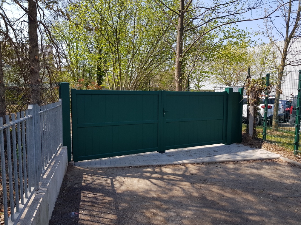 Portail deux battants plein motorisé vert mousse pour une parfaite intégration paysagère à Rossfeld.