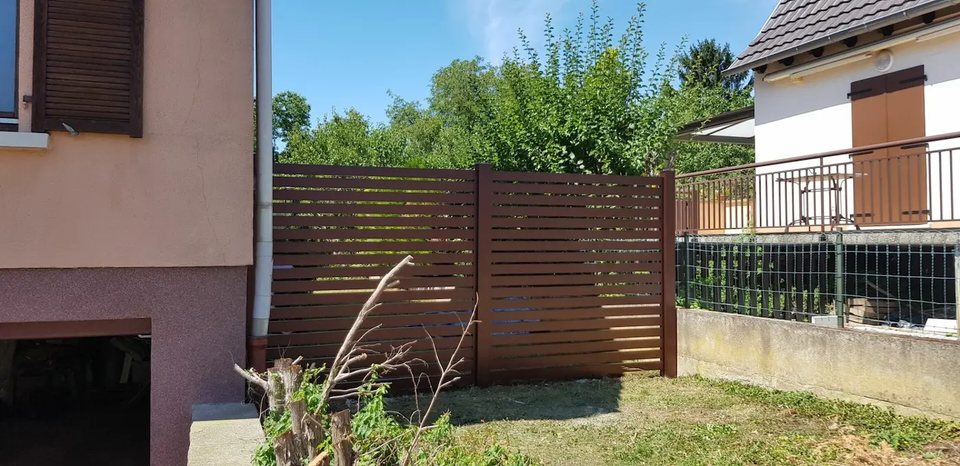 Brise-vue en aluminium marron avec lames horizontales ajourées pour une séparation de terrasse à Sand.