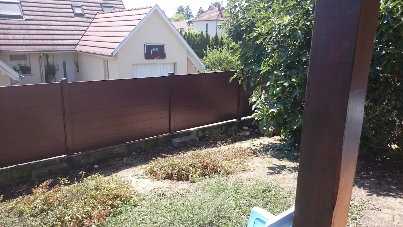 Clôture alu marron installée en brise-vue sur une limite de propriété mitoyenne pour une maison individuelle à Nordhouse