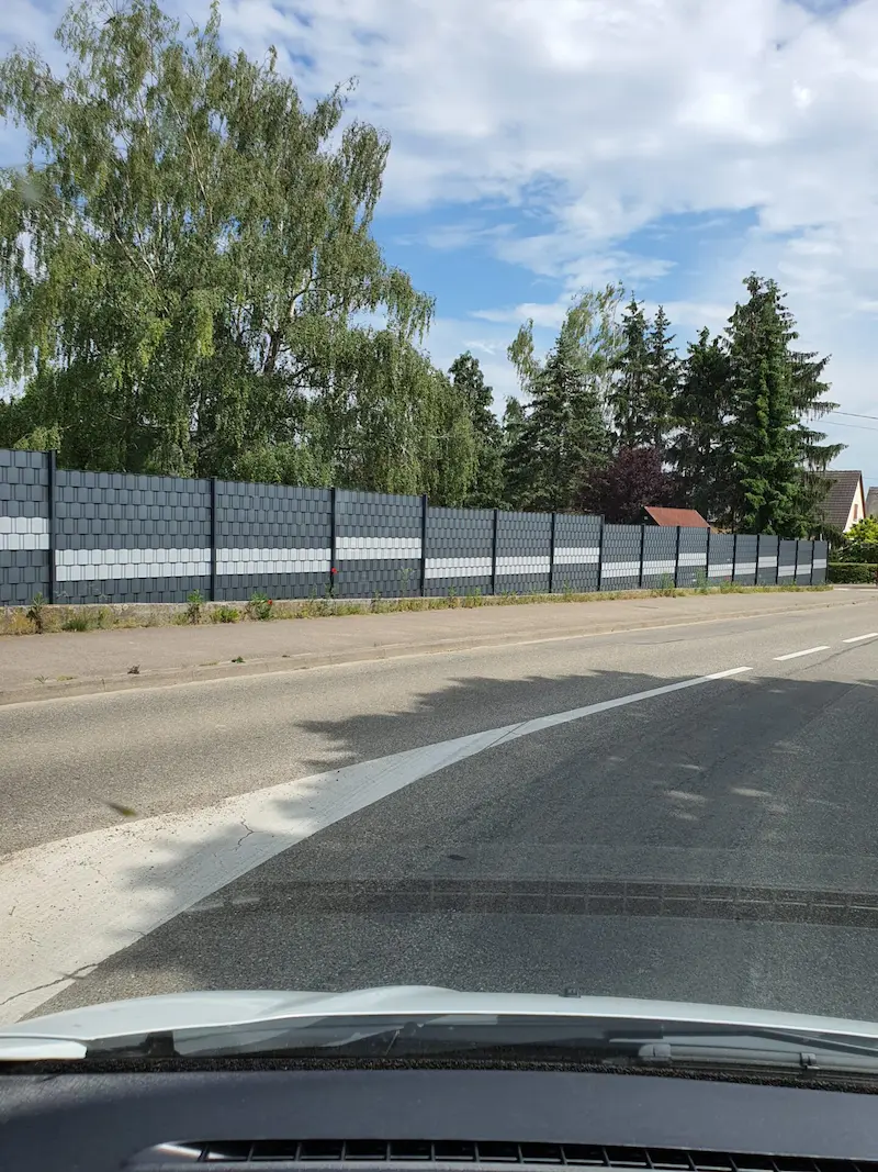 Clôture en grillage rigide occultant sur grande longueur : vue depuis la rue d'une pose en pente à Westhouse