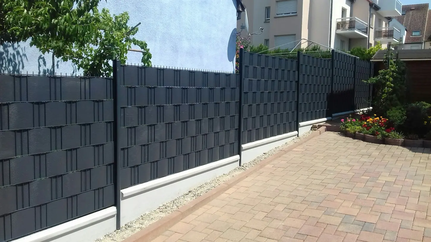 Clôture en grillage rigide avec occultant PVC noir : installation sur terrain en pente réalisée à Benfeld.