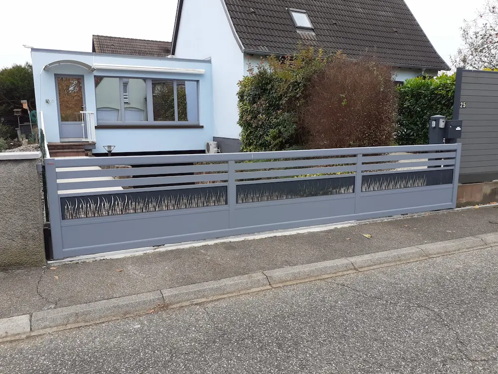Portail coulissant motorisé avec décor laser motif herbe et soubassement plein à Ebersheim.