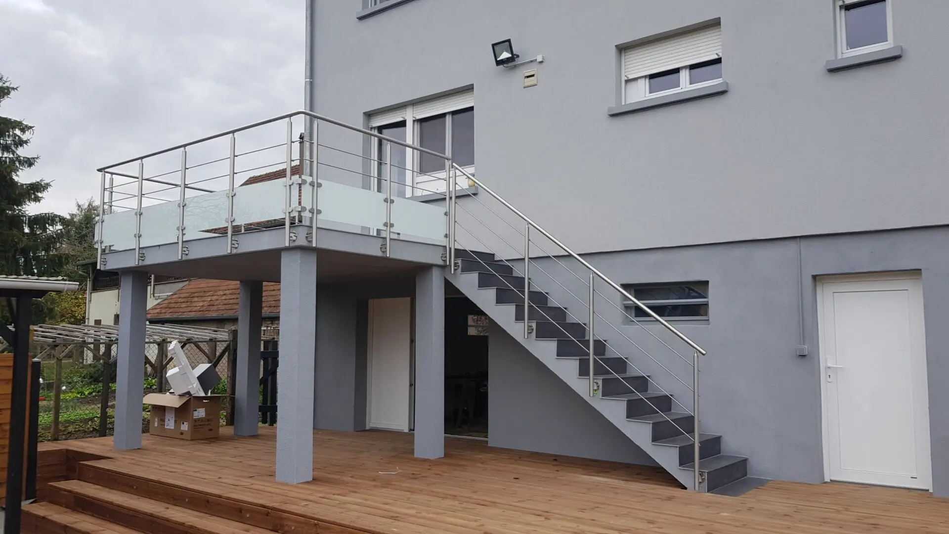 Garde-corps en aluminium brut avec soubassement vitré sécurisant une terrasse et un escalier extérieur, offrant une vue dégagée et un style industriel à Sélestat.