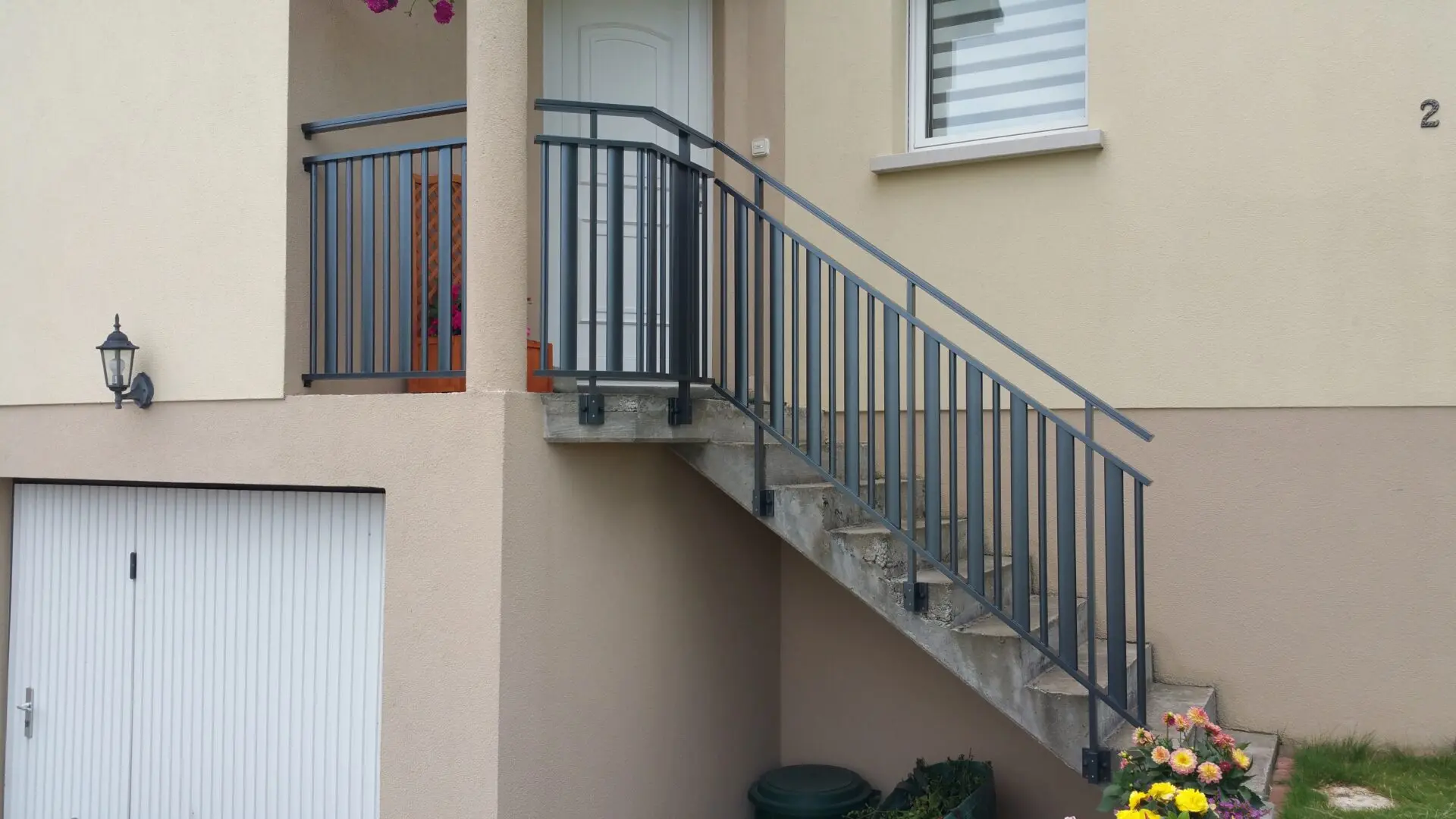 Garde-corps d'escalier d'entrée en aluminium gris anthracite avec remplissage à lames verticales, offrant un accueil sécurisé et moderne à Goxwiller