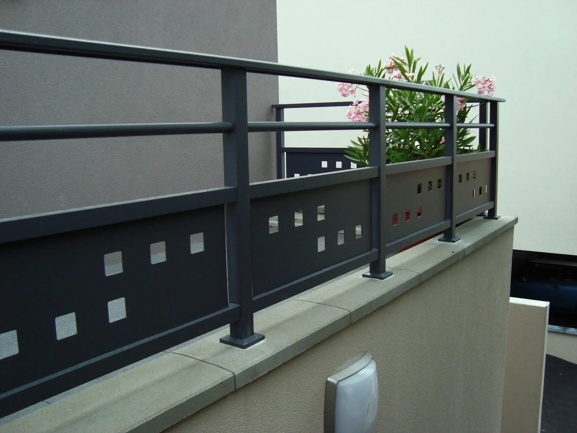 Garde-corps en aluminium foncé avec un soubassement design à découpe laser motifs carrés, apportant une touche graphique et contemporaine à une terrasse à Bischoffsheim