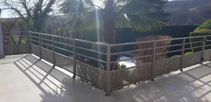 Garde-corps en aluminium gris clair avec soubassement en tôle micro-perforée, offrant une protection visuelle sans bloquer l'air pour une terrasse à Benfeld.