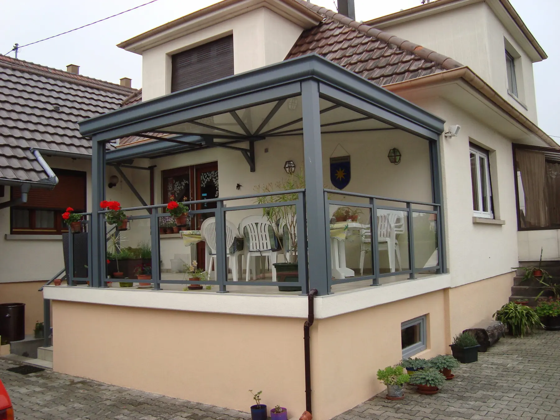 Aménagement extérieur harmonieux à Entzheim comprenant une pergola et un garde-corps en aluminium gris anthracite assortis, avec remplissage vitré pour une finition moderne signée Activ'EST.