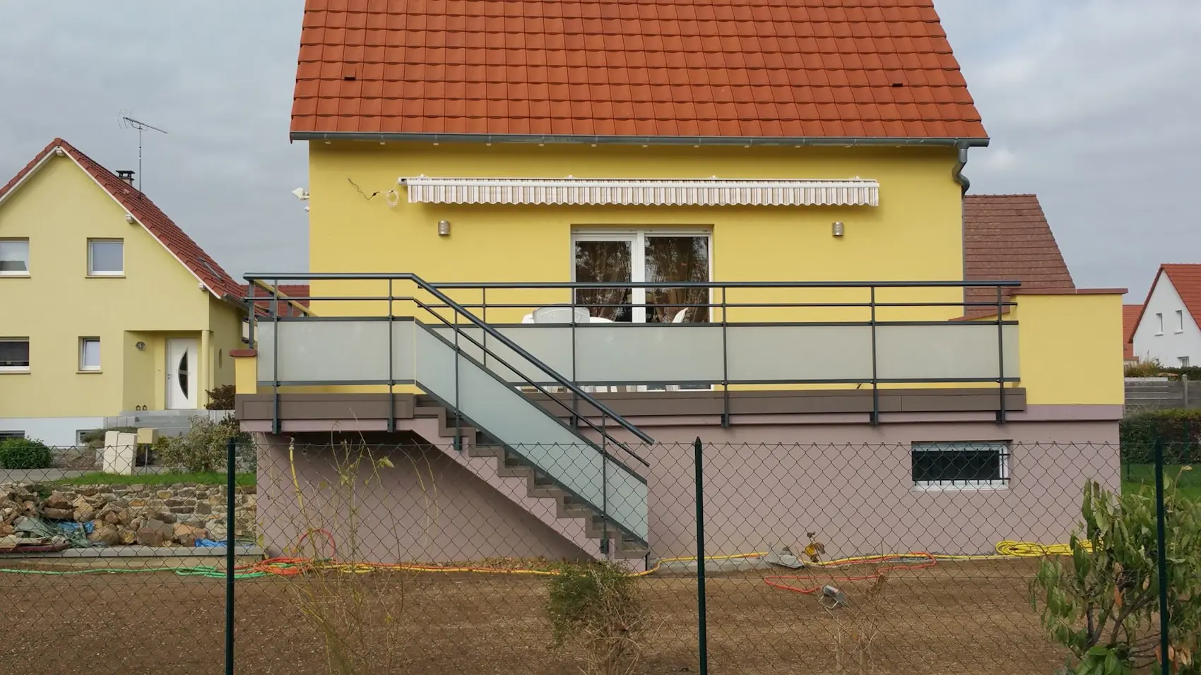 Garde-corps en aluminium avec vitrage opaque et main courante surélevée, sécurisant à la fois la terrasse et l'escalier d'une maison à Innenheim.